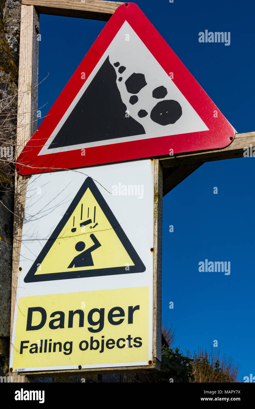 Eine Warnung oder beratenden Zeichen informieren die Menschen über die Gefahren von fallenden Steinen oder Felsen von einer Klippe am Meer. Gefahrzeichen und Warnung. Stockfoto