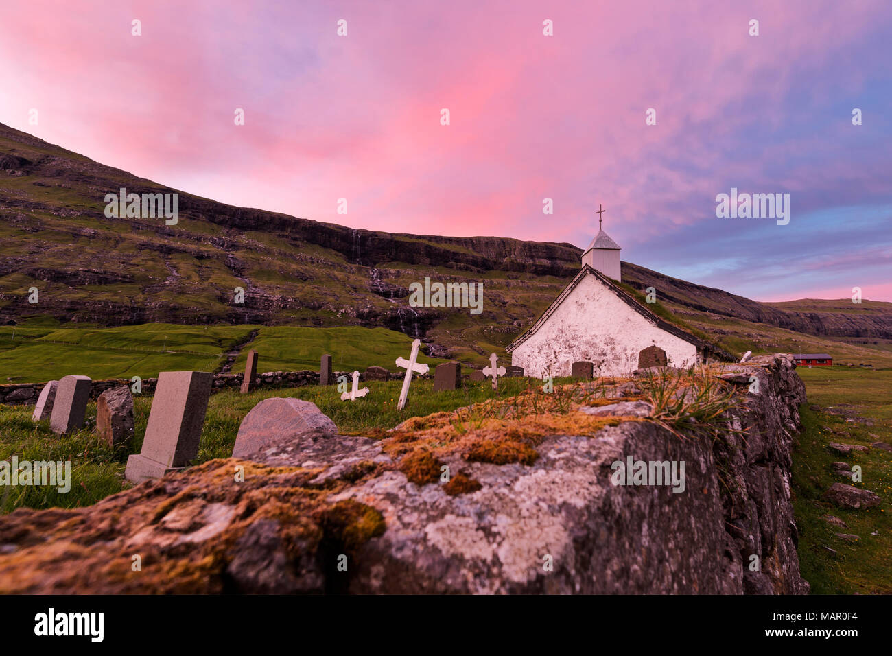 Rosa Sonnenuntergang auf Kirche und Friedhof, Saksun, Streymoy Island, Färöer, Dänemark, Europa Stockfoto