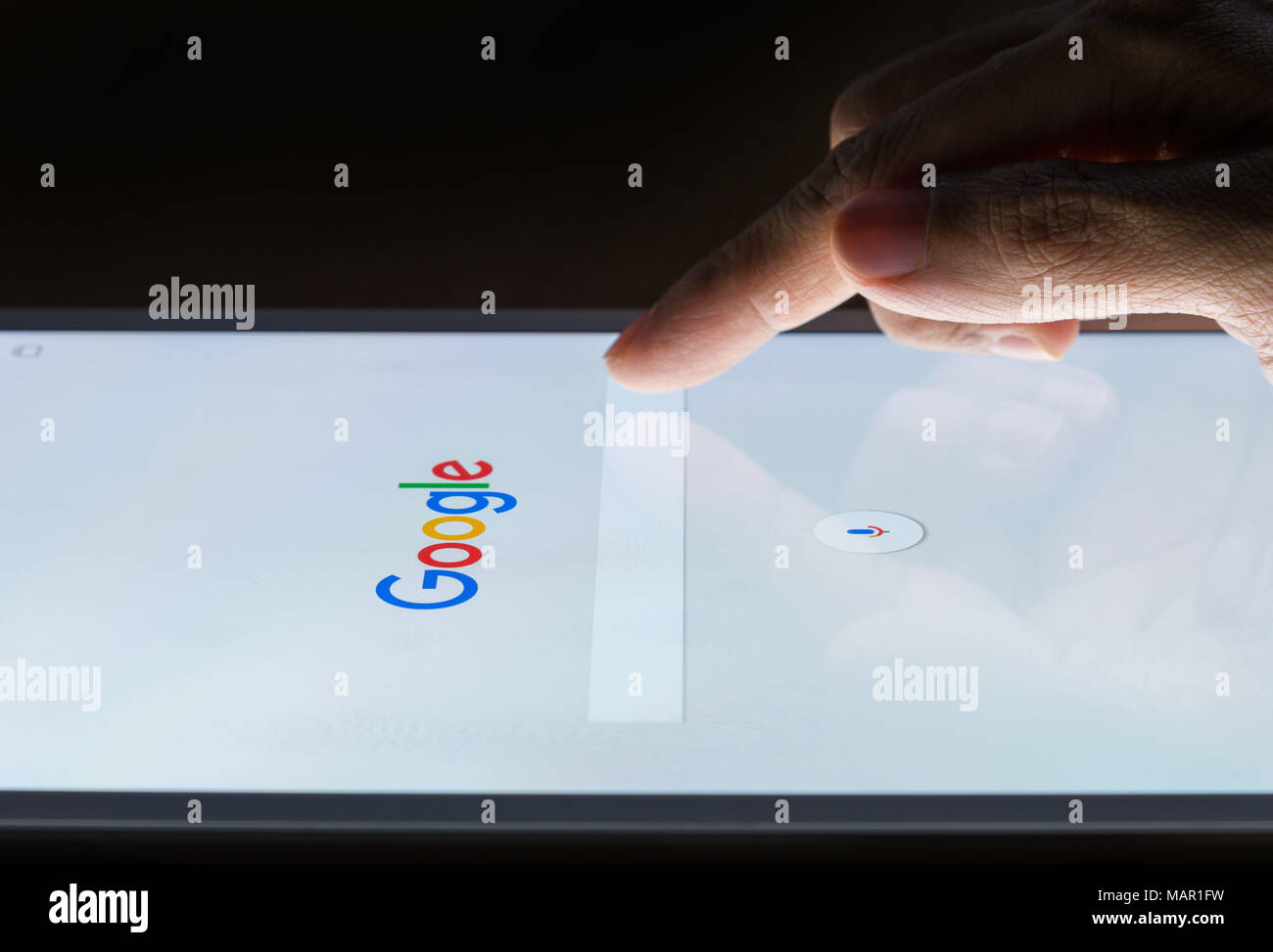BANGKOK, THAILAND - 19. FEBRUAR 2017: die Hand eines Mannes berührt auf intelligente Geräte in der Nacht für die Suche bei Google Search Engine. Google ist das m Stockfoto