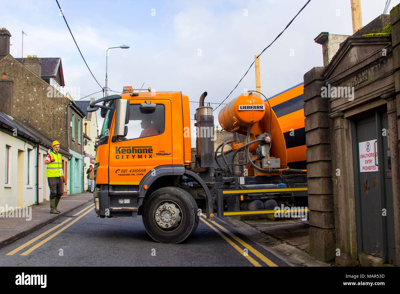Ein Arbeiter in Hi-Viz Kleidung mit Wegbeschreibungen zu den Fahrer eines Bulk konkrete Lieferung Lastwagen in die Stadt Cork Irland Stockfoto