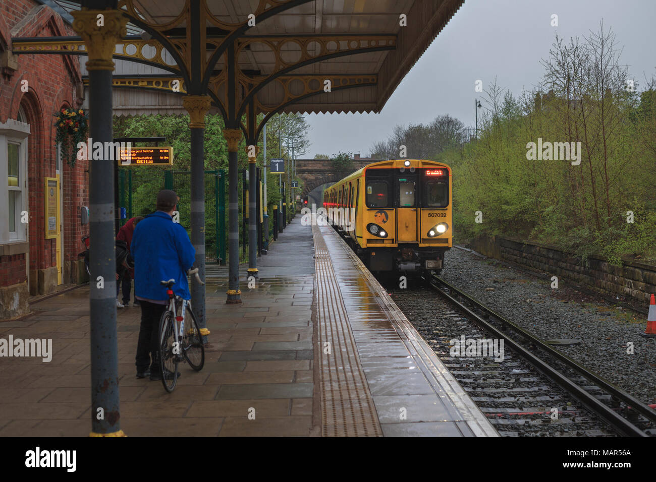 Ein merseyrail Zug in Ormskirk Bahnhof aus Liverpool mit einem Radfahrer warten in den Zug mit seinem Fahrrad zu Stockfoto
