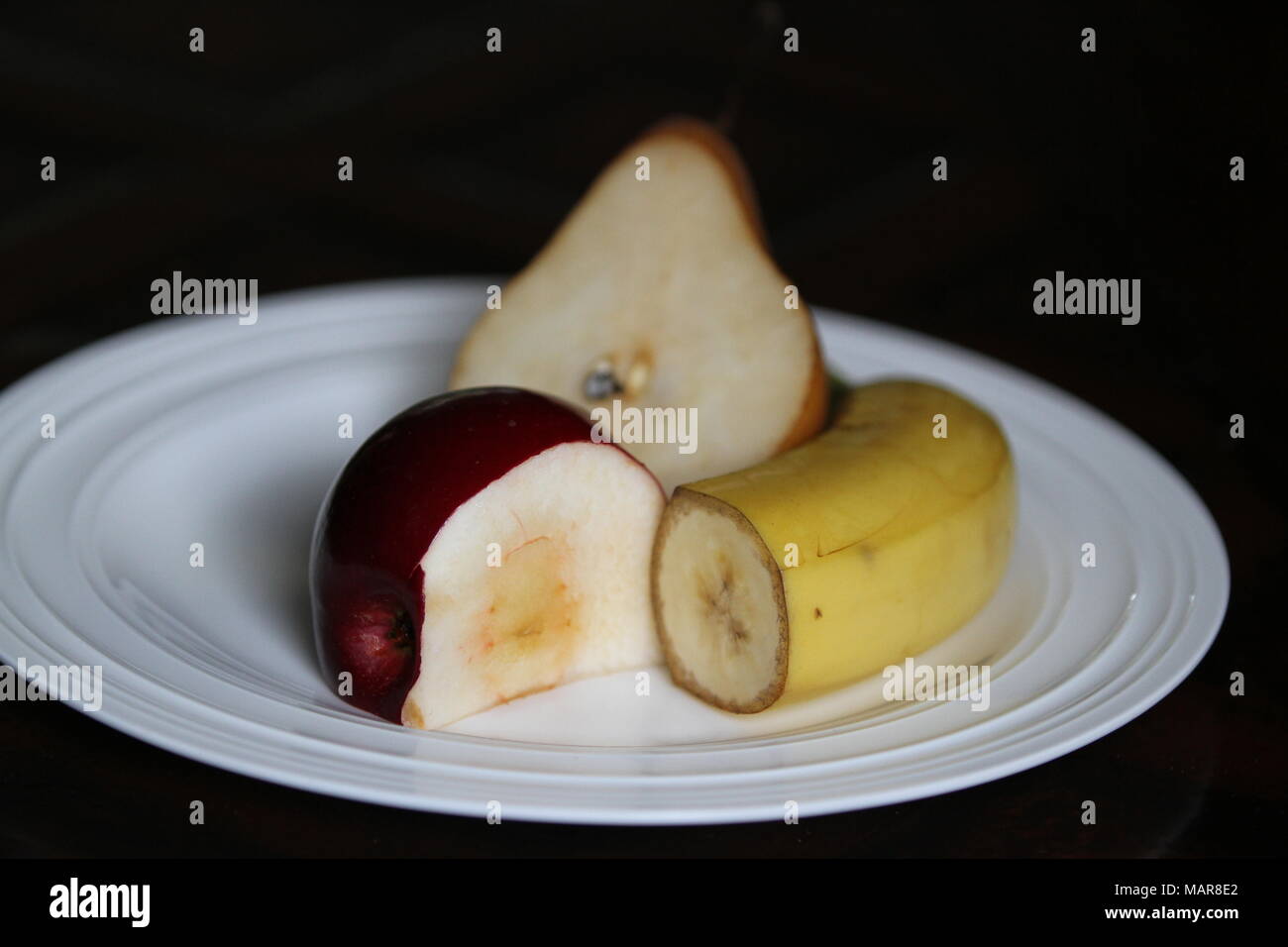 Banane, Apfel und Birne schneiden, auf einer Platte Stockfoto
