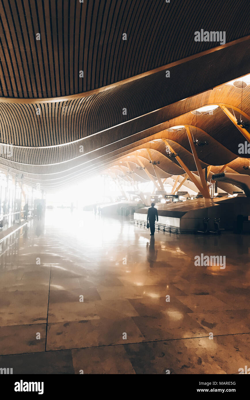Madrid, Spanien - 15. Februar 2017: Alleinreisende wandern im sonnigen Terminal von Adolfo Suarez Madrid Barajas Flughafen Stockfoto