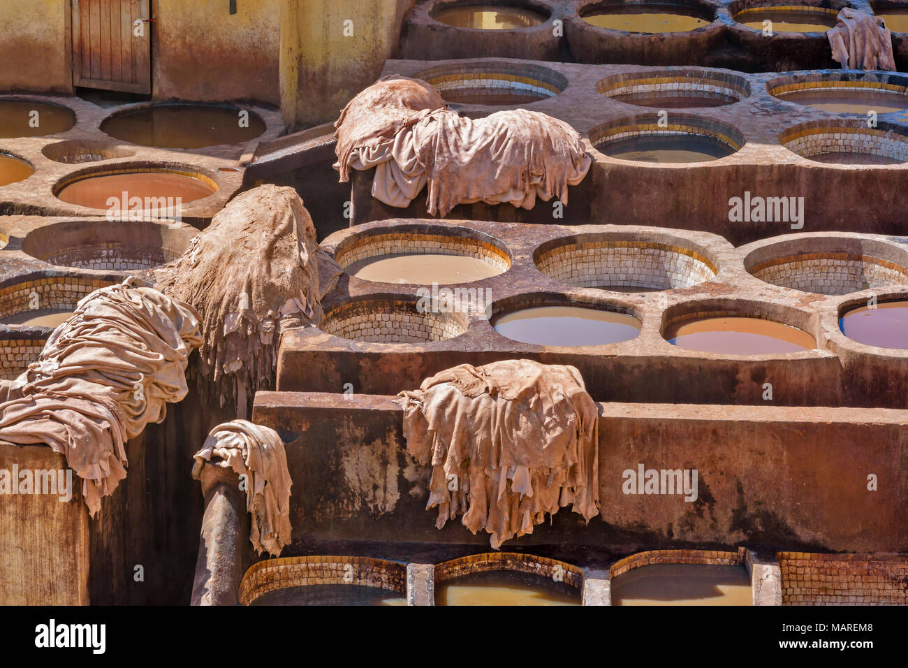 Marokko Fes Medina Souk CHOUWARA GERBEREI GERBEREIEN RUNDSCHREIBEN Fässer oder Tanks mit bunten FARBSTOFFE ENTHALTEN, DIE HÄUTE GESTAPELT SKINS ENTFERNT DIE Stockfoto