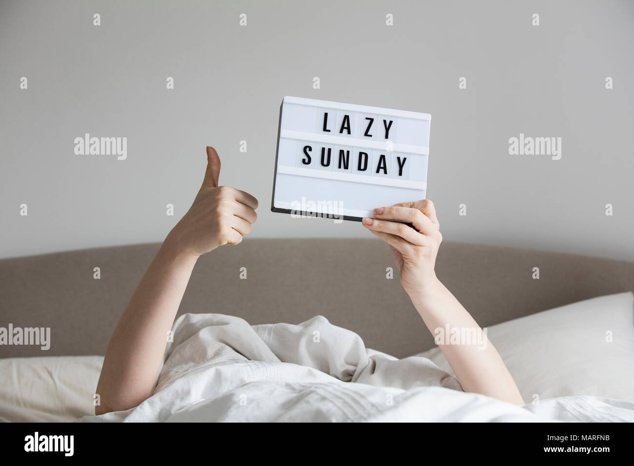 Frau im Bett unter den Blättern einen faulen Sonntag anmelden Stockfoto