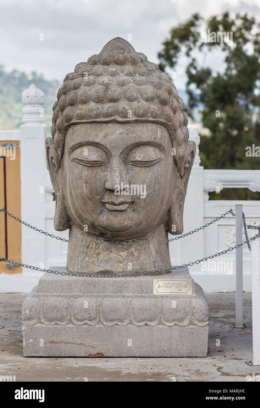 Hacienda Heights, CA, USA - 23. März 2018: Nahaufnahme von Teh Buddha Kopf steinerne Statue am Eingang Tor zu Hsi Lai buddhistischen Tempel unter schweren weißen Clo Stockfoto