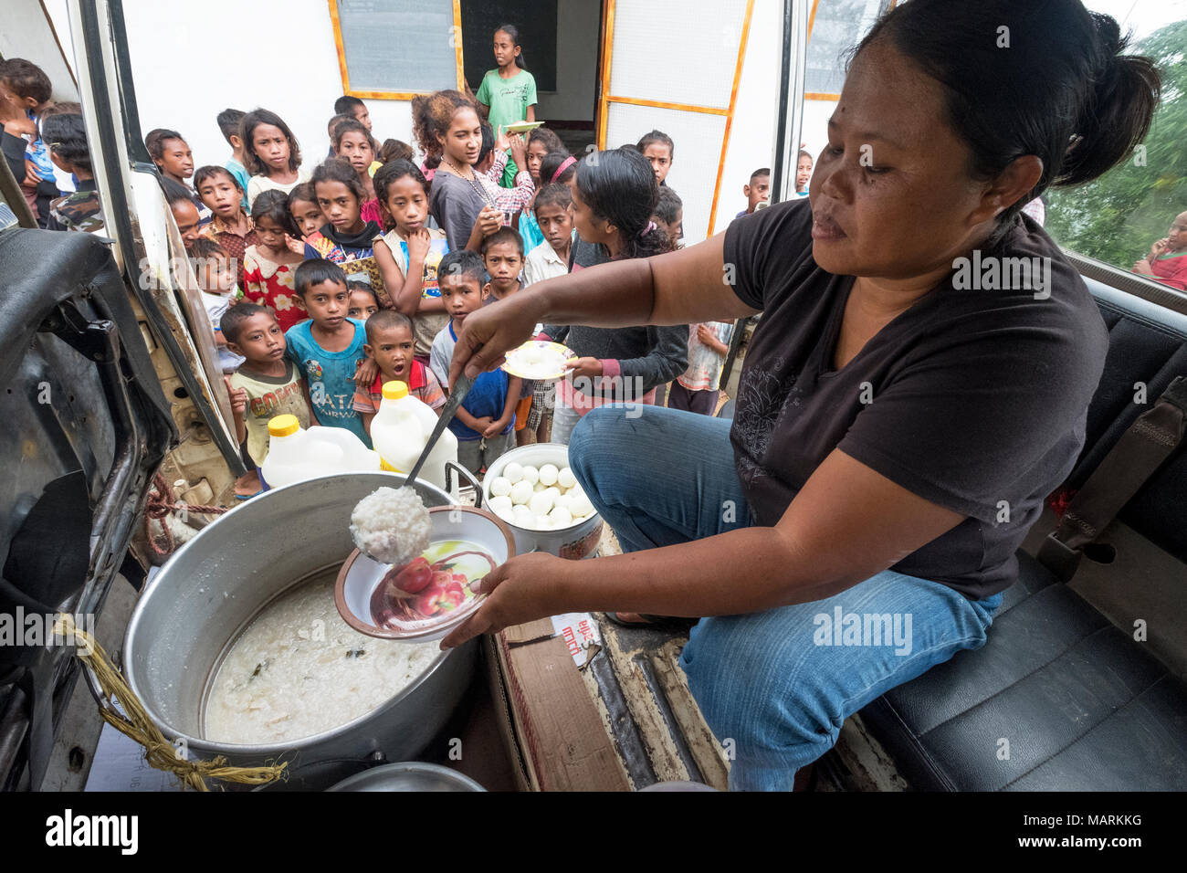 Christina Haryunika, Koordinator eines Jesuiten Ernährungsprogramm, verteilt Nahrungsmittel für unterernährte Kinder in Cocoa Village, Distrikt Ermera, Timor-Leste. Christina reist in den drei Dörfern fast täglich zu Handout Mahlzeiten. Viele Dorfbewohner in den ländlichen Gebieten haben große Familien, die sie nicht unterstützt, so dass eine grosse Zahl der Kinder an Unterernährung leiden. Stockfoto