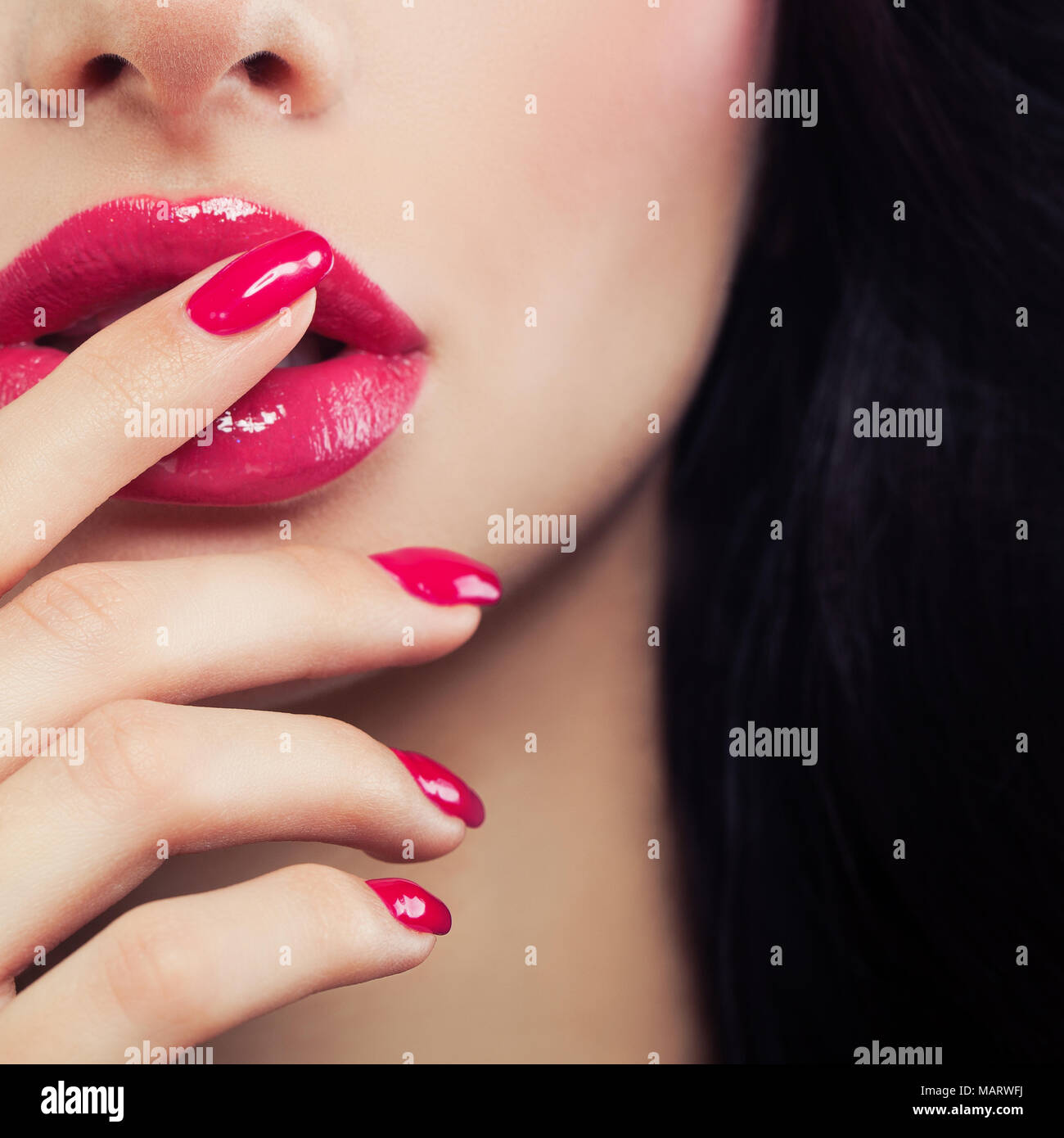 Rosa weibliche Lippen und Maniküre Hand schließen. Lipgloss Make-up, Beauty Hintergrund Stockfoto