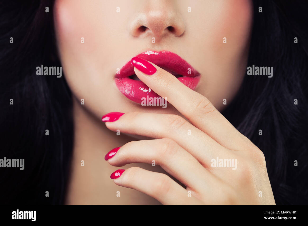 Frau berührte ihre Lippen ihre Hand mit Maniküre. Make-up Lippen mit rosa  Lippenstift, glänzend Stockfotografie - Alamy