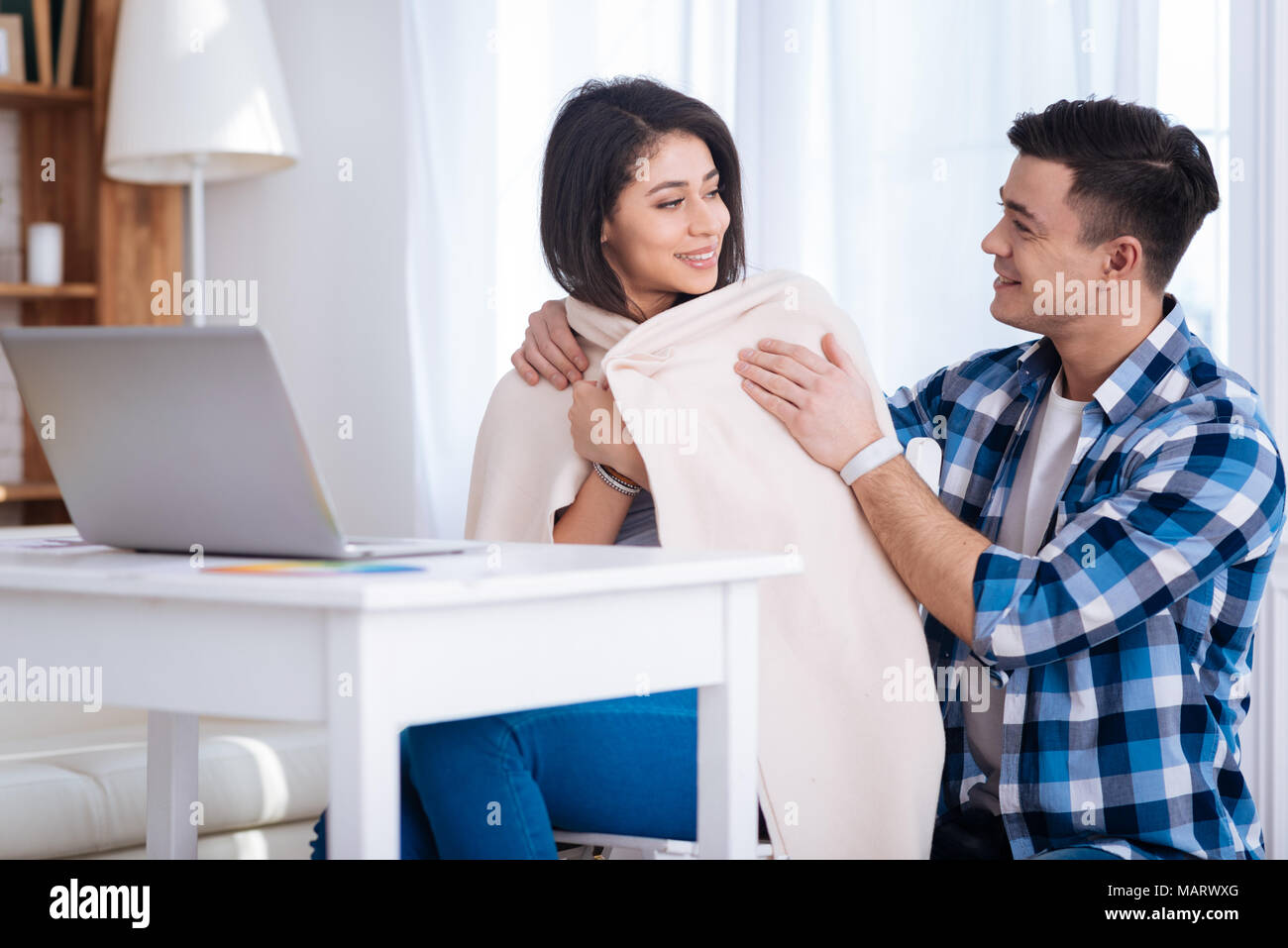 Mann schlägt Decke, um ansprechende Frau Stockfoto