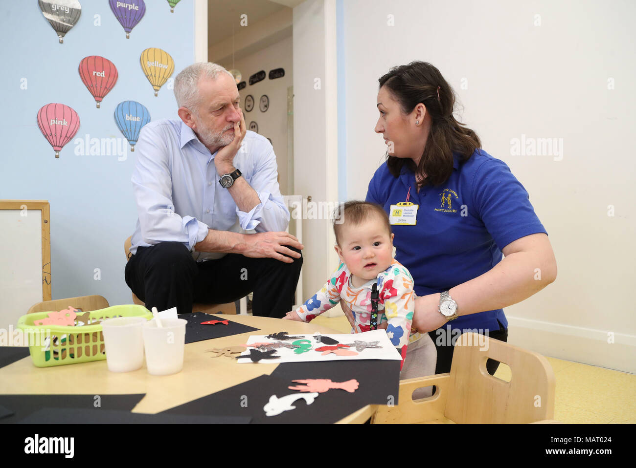 Der Führer der Jeremy Corbyn spricht von einer Kindergärtnerin, die während eines Besuchs auf Wenig Teilnehmer Baumschule in Watford an den steigenden Kosten der Kinderbetreuung zu markieren. Stockfoto