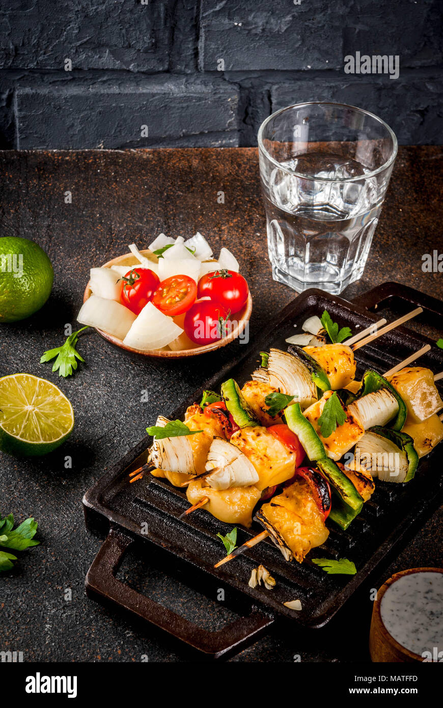 Vegane Ernährung Essen, gegrillten Käse und Gemüse Kebab, im indischen Stil Paneer Tikka, mit weißer Soße und Kalk, auf dunklen konkreten Hintergrund, kopieren Raum Stockfoto