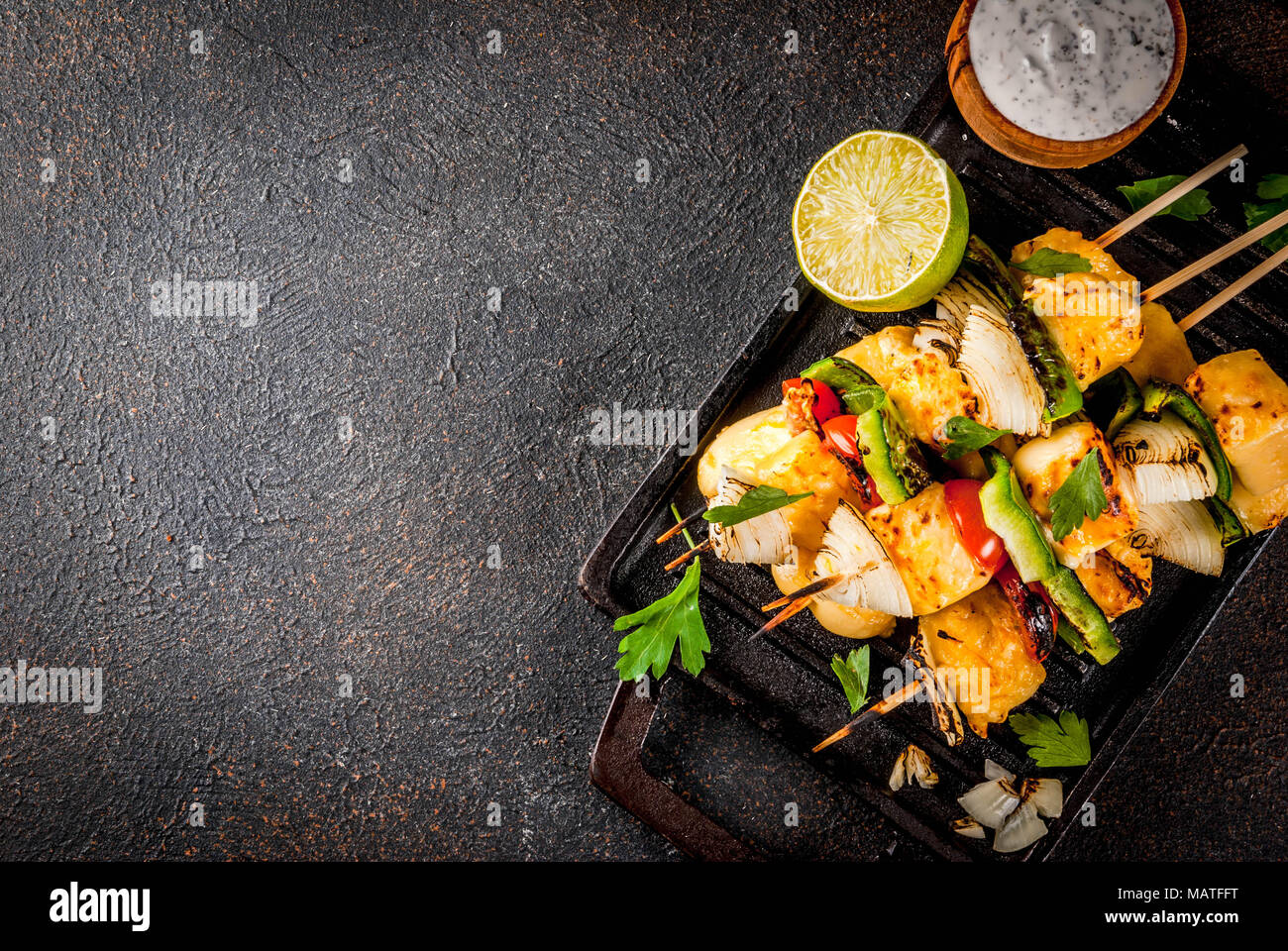 Vegane Ernährung Essen, gegrillten Käse und Gemüse Kebab, im indischen Stil Paneer Tikka, mit weißer Soße und Kalk, auf dunklen konkreten Hintergrund, kopieren, um Platz zu Stockfoto
