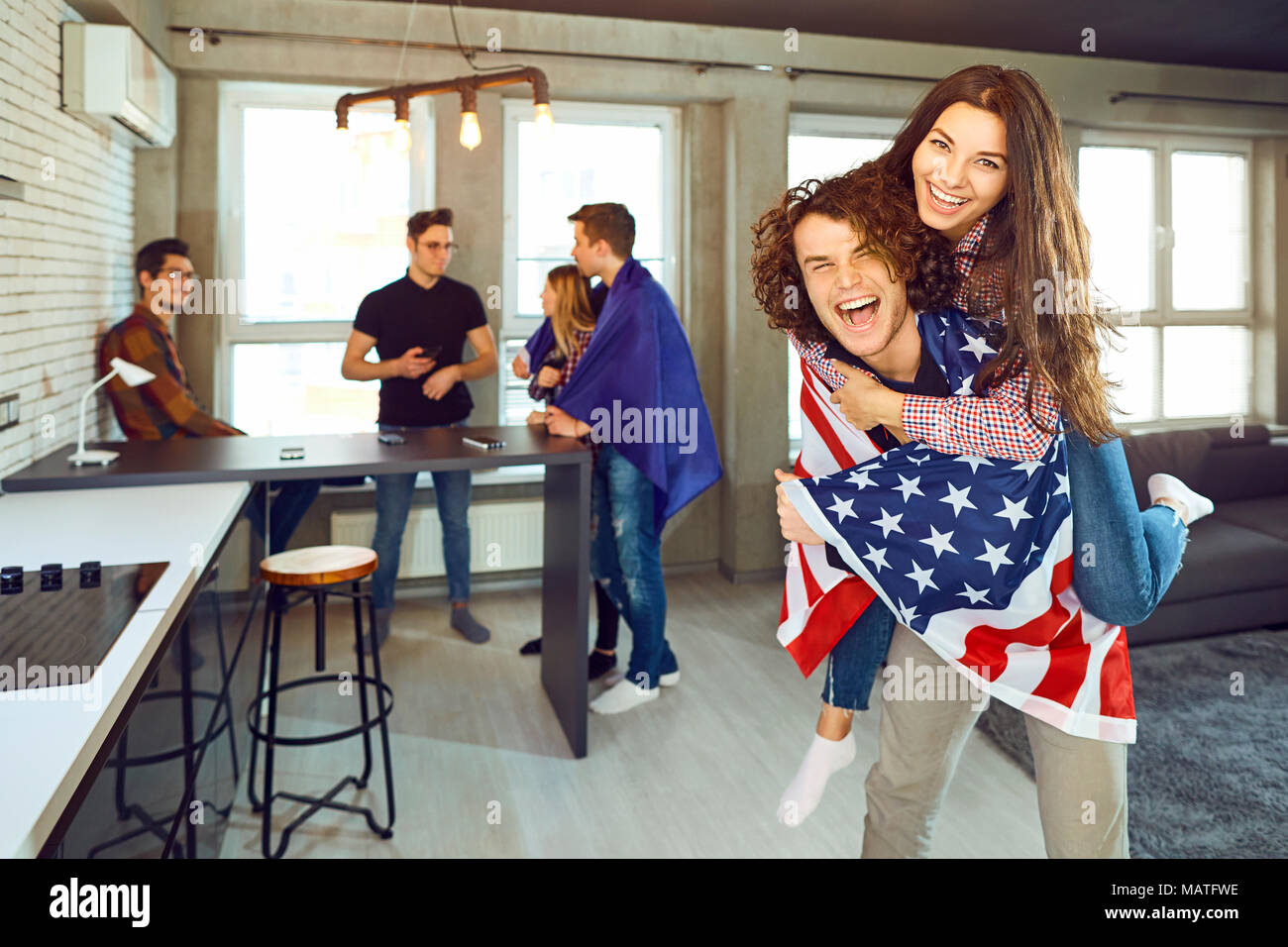 Freunde mit amerikanischen Fahnen Lachen im Innenbereich. Stockfoto Freunde mit amerikanischen Fahnen Lachen im Innenbereich. Stockfoto