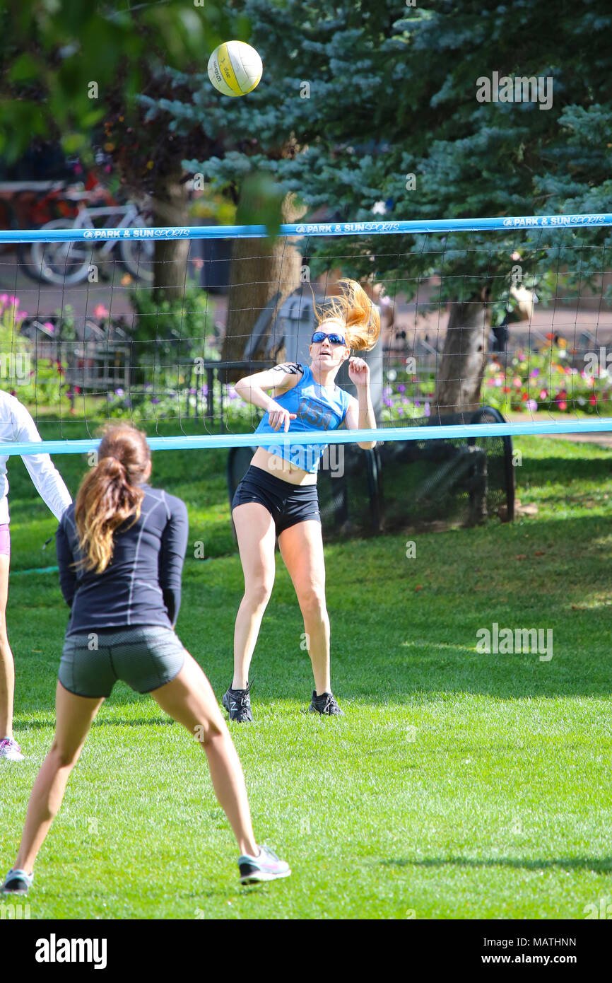 Junge Frauen spielen Volleyball auf Gras Feld in Aspen, Colorado Stockfoto
