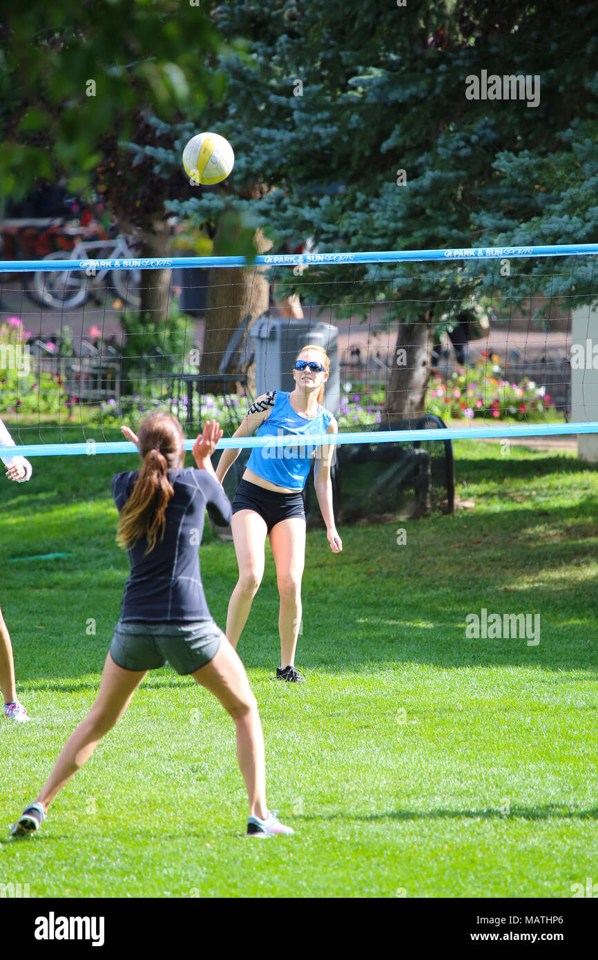 Junge Frauen spielen Volleyball auf Gras Feld in Aspen, Colorado Stockfoto