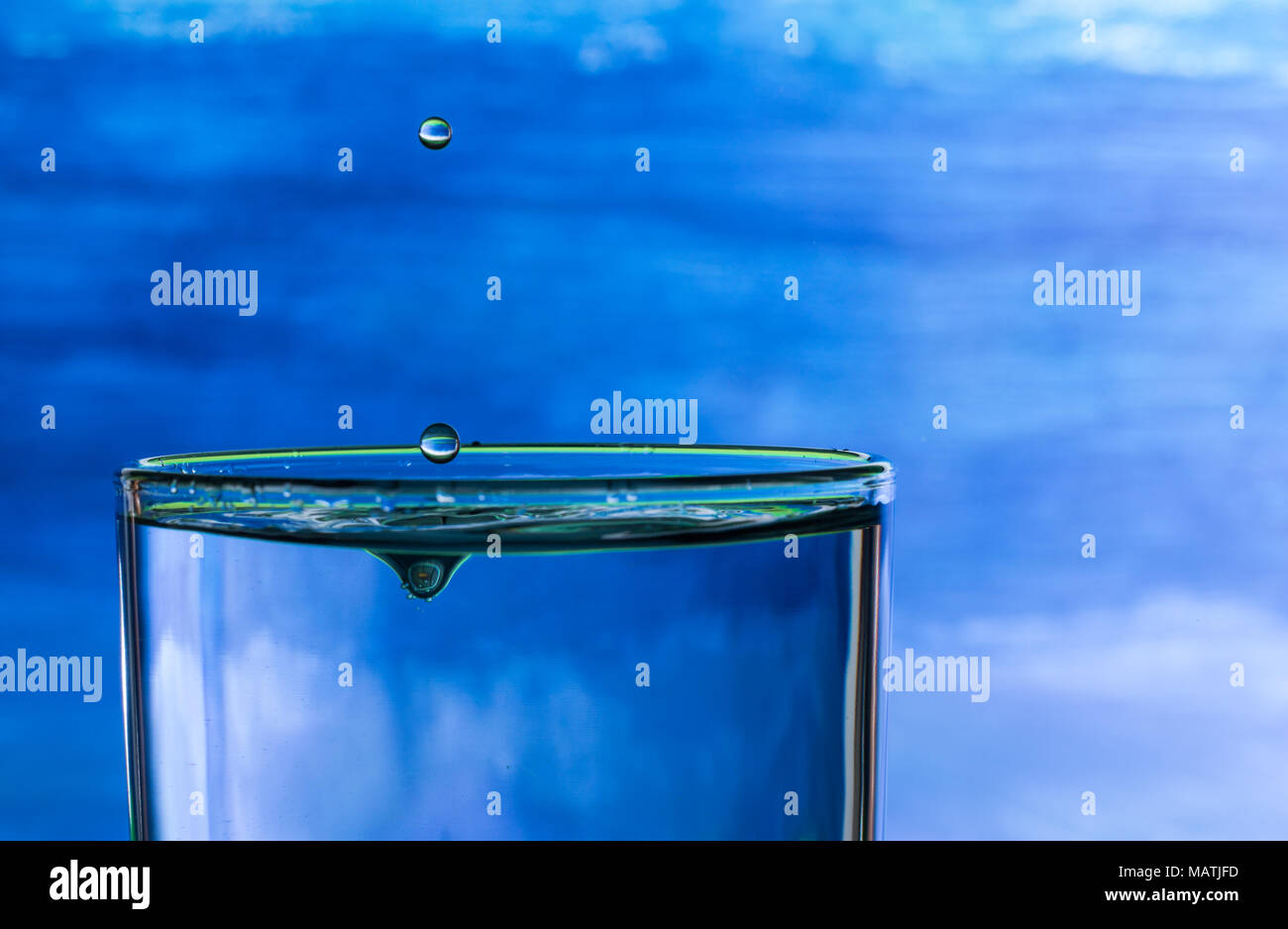Wassertropfen spritzen in einem Glas Trinkwasser Stockfoto