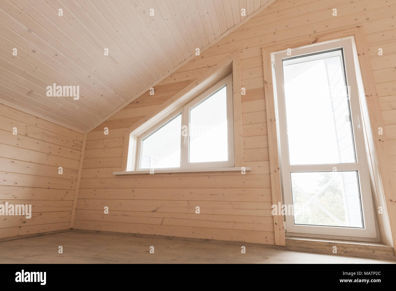 Leere Holzhaus Innenraum, Dachgeschoss Zimmer mit Fenster und Balkontür Stockfoto