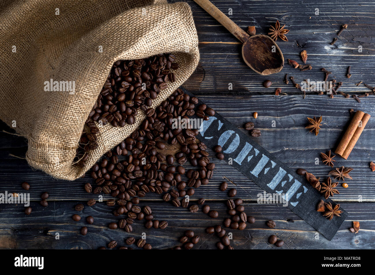 Titel Kaffee mit Holz- Hintergrund, Jute Tasche, Gewürze und Kaffee Bohnen Stockfoto