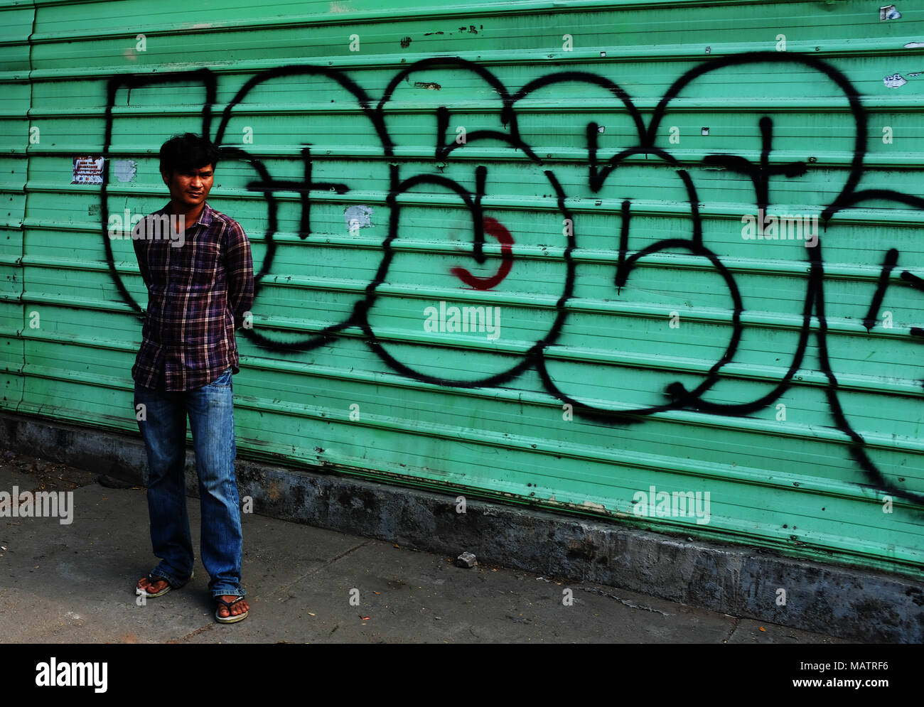 Einsame Figur gegen einen Graffiti Hintergrund, Phnom Penh Stockfoto