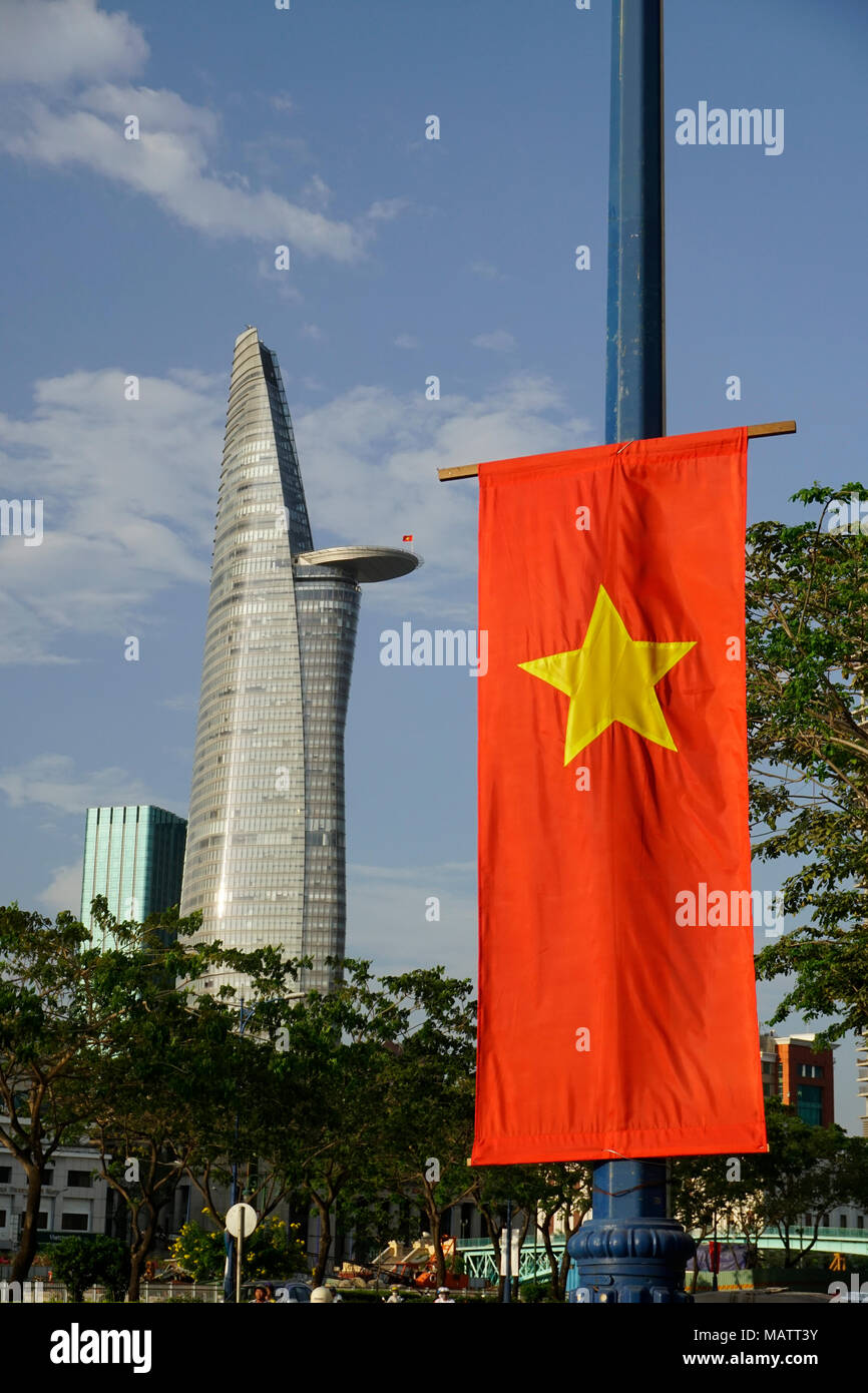 District 1, Ho Chi Minh City, Vietnam. Die bitexco Financial Tower. Von Carlos Zapata gestaltet. Vietnamesische Flag im Vordergrund. Stockfoto