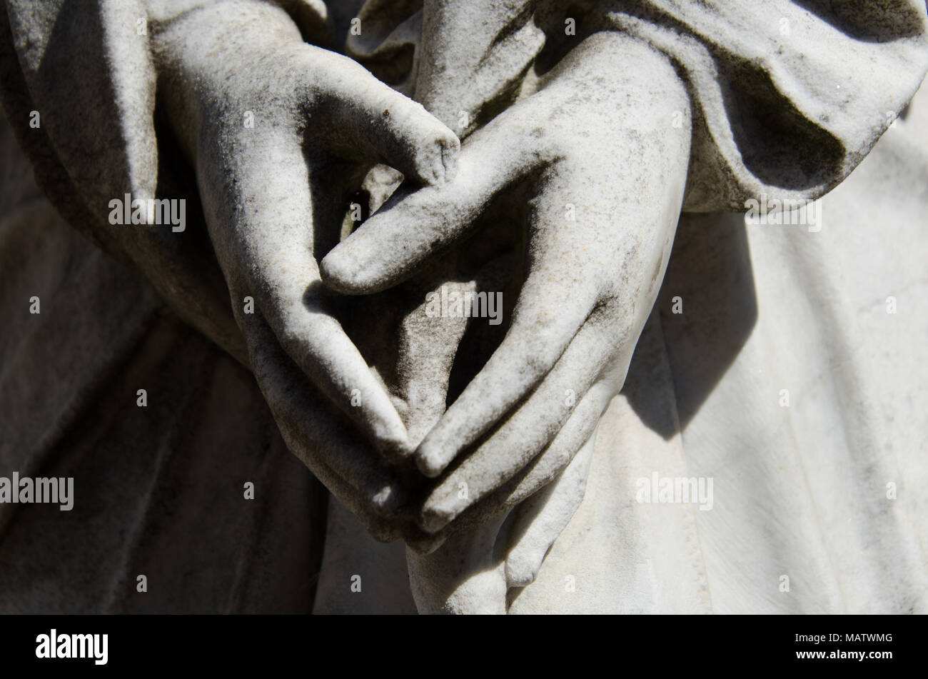 Nahaufnahme der Statue Händen zu beten. Helles Sonnenlicht auf weibliche Hände in Beten auf tombstone Statue. Stockfoto