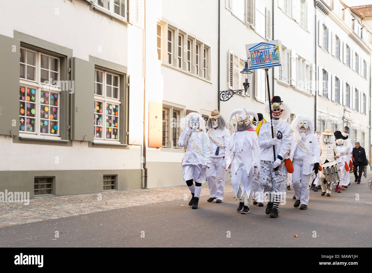 Basler Fasnacht. Augustinergasse, Basel, Schweiz - Februar 21., 2018. Karneval Gruppe in Weiß Kostüme in der Altstadt Stockfoto