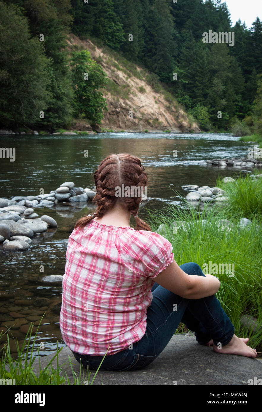 Ein junges Mädchen mit Blick auf einen Fluss. Stockfoto