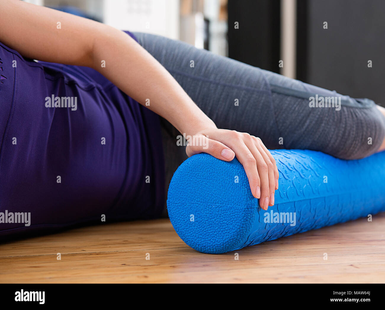 Eine Frau, die rollenden ihr Bein mit einer schaumstoffrolle Stockfoto