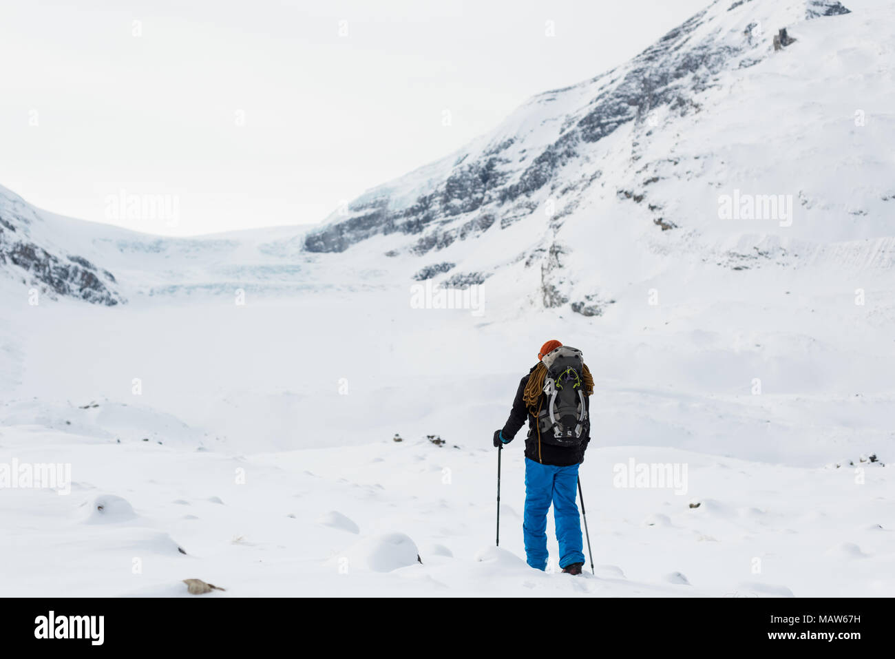 Männliche Bergsteiger wandern auf einem schneebedeckten Berg im Winter Stockfoto
