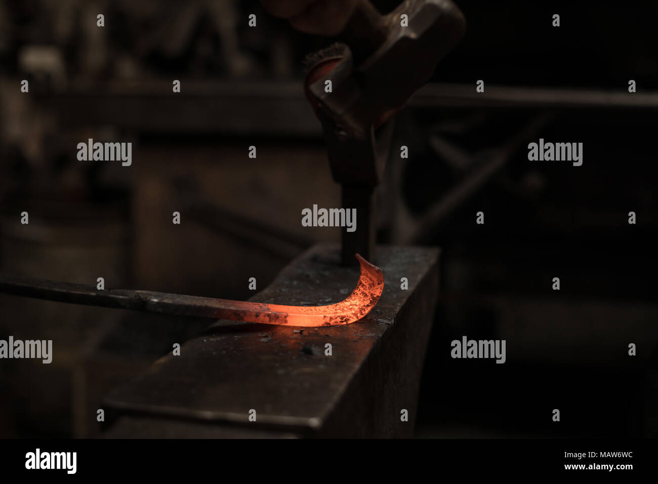 Schmied hämmern ein heißes Metall Stange Stockfoto