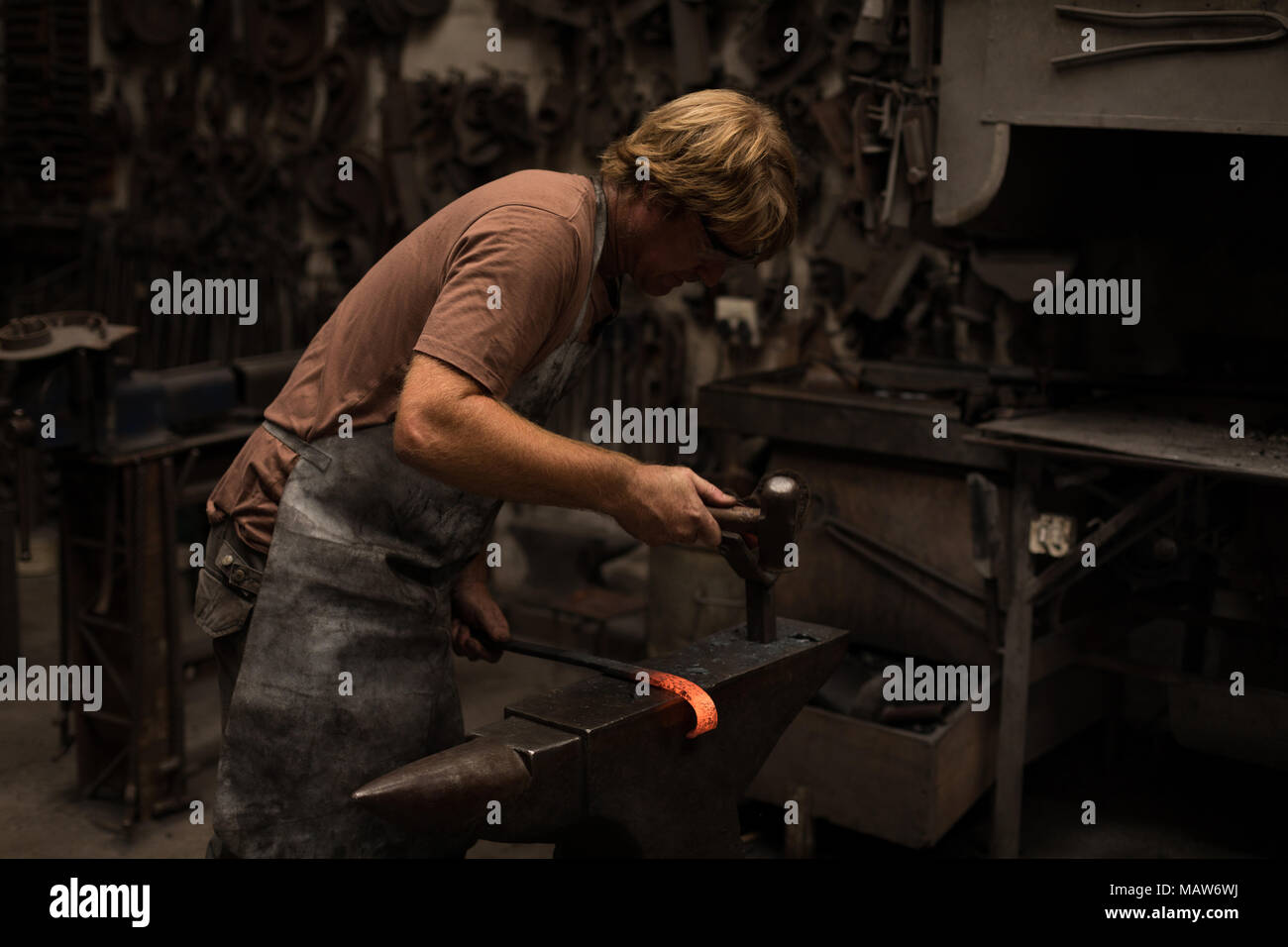 Schmied hämmern ein heißes Metall Stange Stockfoto