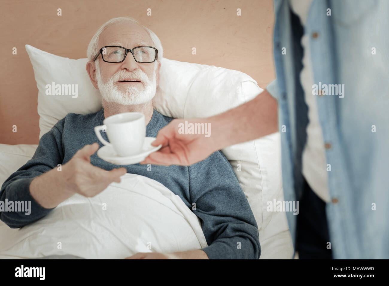 Senior unshaken Mann liegen und dabei eine Tasse. Stockfoto