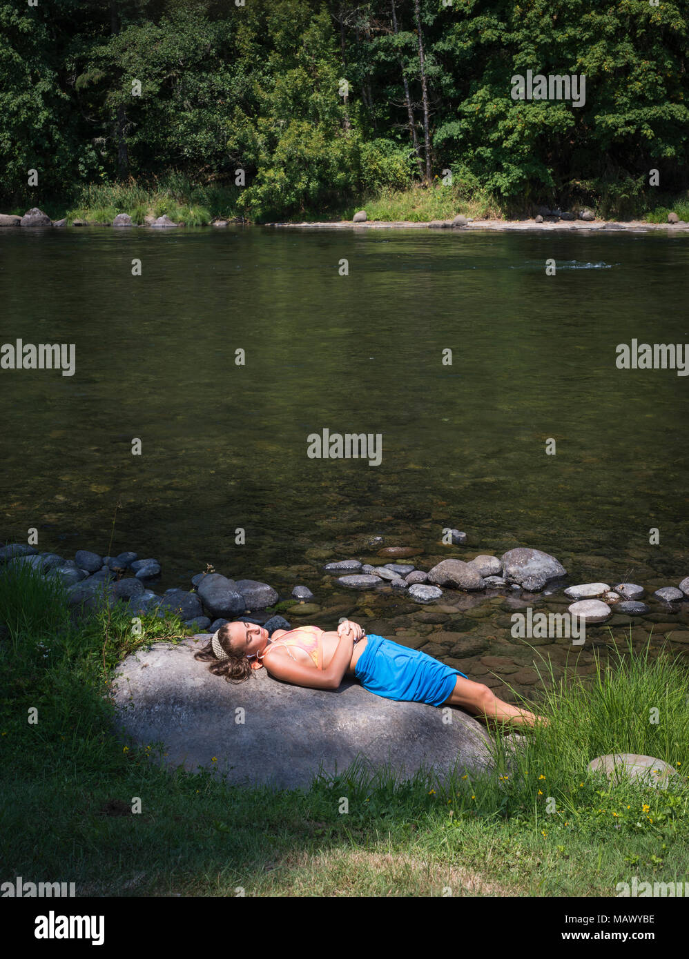 Eine junge Frau auf einem Rock Musik hören Stockfoto