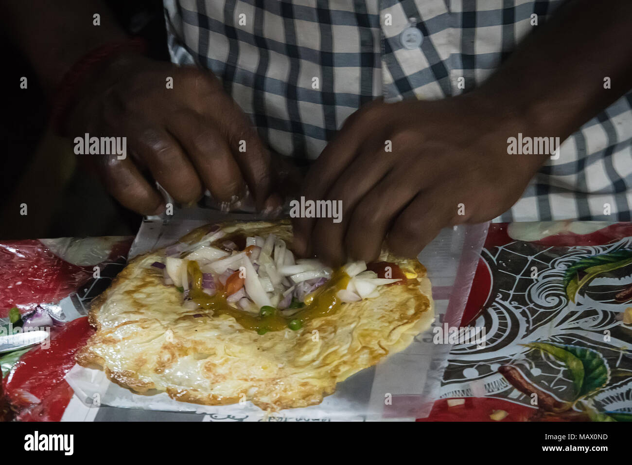 Indien Pfannkuchen Roti kochen. Traditionelle indische Essen. ein Mann ein Omelett zu einer Rolle wird mit Gemüse gefüllt. Neil Insel, Andamanen und Nikobaren, Indi Stockfoto