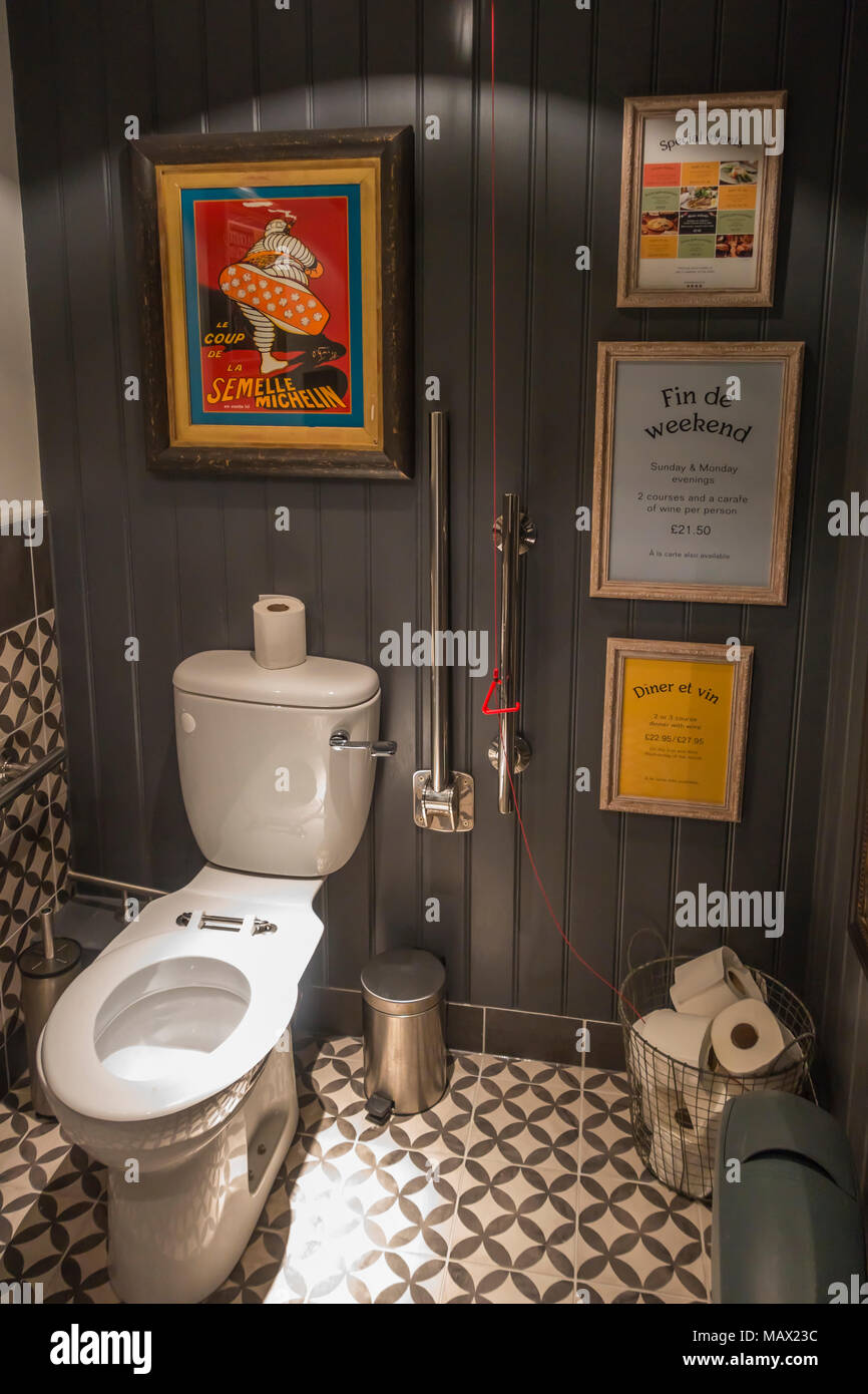 Eine gut ausgestattete behindertengerechte Toilette in einem Restaurant im französischen Stil mit bunten Plakaten Stockfoto