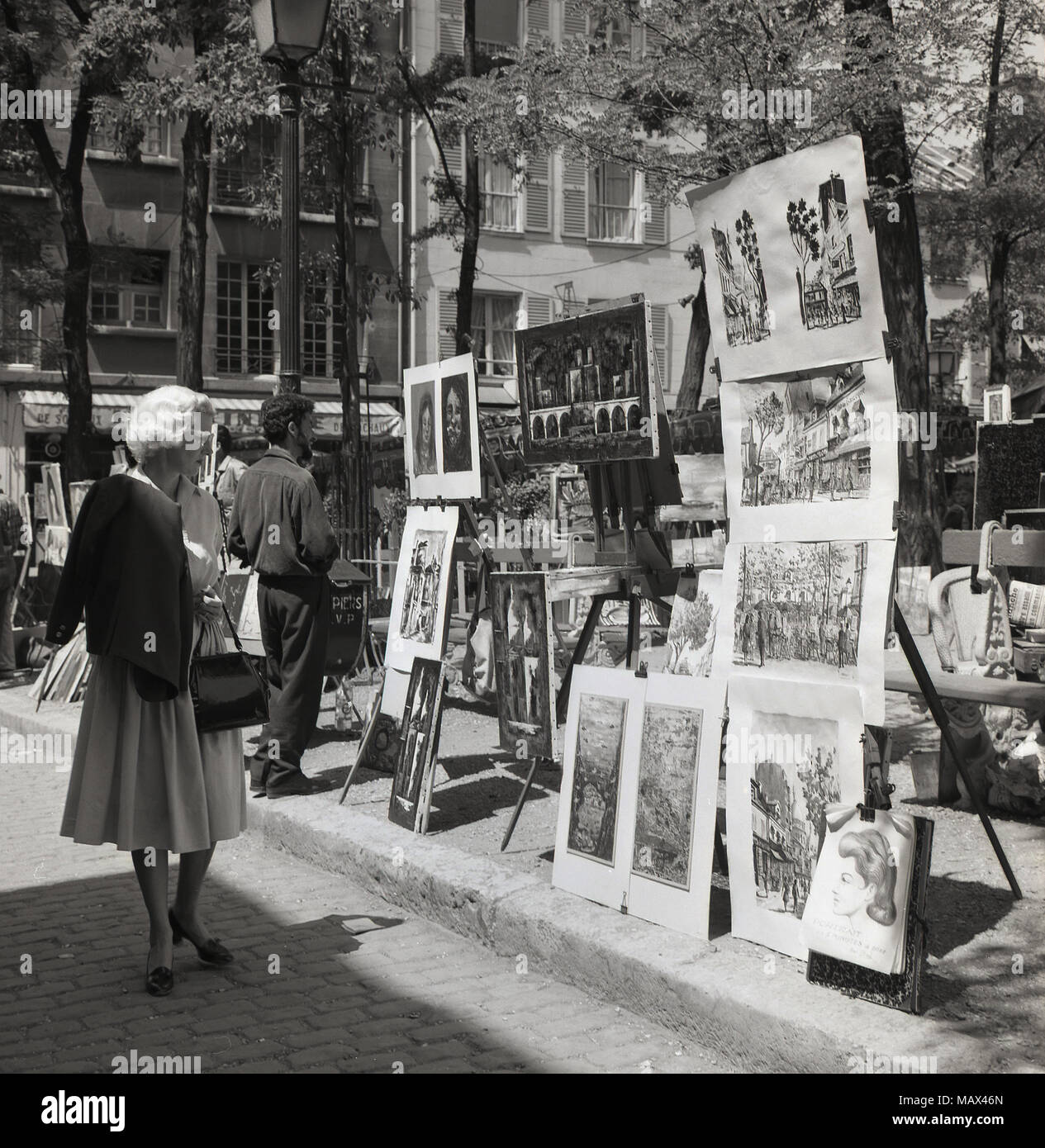 1950er Jahre, historische Bild, Gemälde und Kunstwerke zum Verkauf auf dem 'Place du Tertre', ein berühmter Platz am Montmartre, Paris, Frankreich. Das Gebiet ist bekannt für seine Künstler auf der Straße bekannt und es gibt viele davon, die in der Vergangenheit gelebt haben und dort arbeitete, einschließlich Renoir und Picasso, Stockfoto