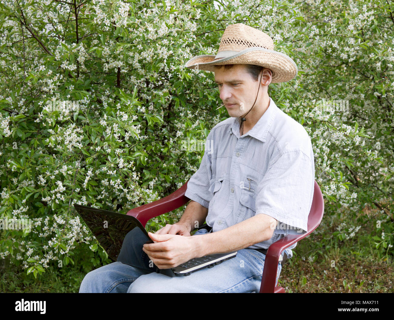 Ein junger Mann in einer Kirsche Garten im Frühjahr Stockfoto