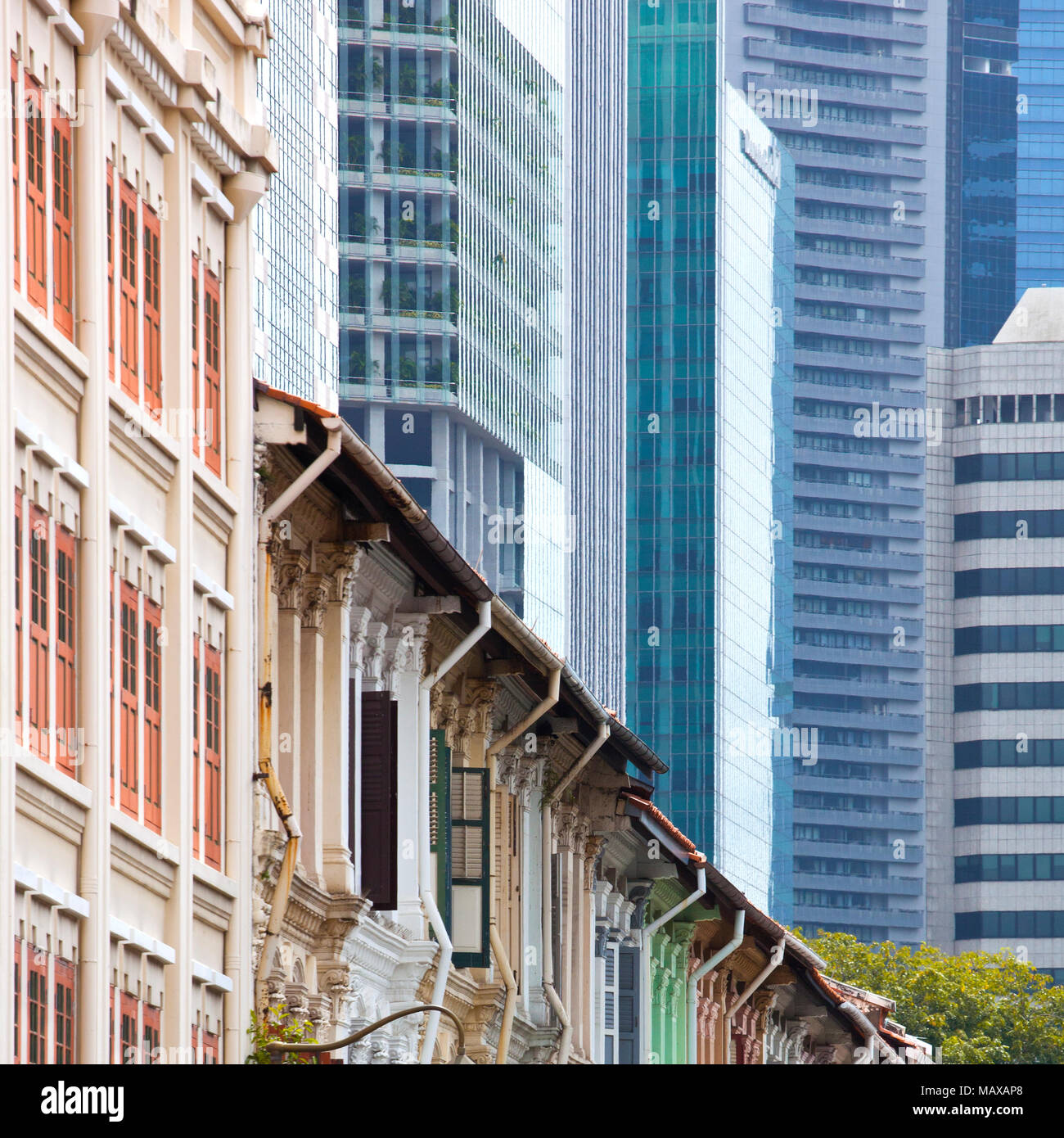 Alte Häuser mit farbigen Fensterläden mit den Städten finanzielle Wolkenkratzer in der Ferne in Singapur Stockfoto