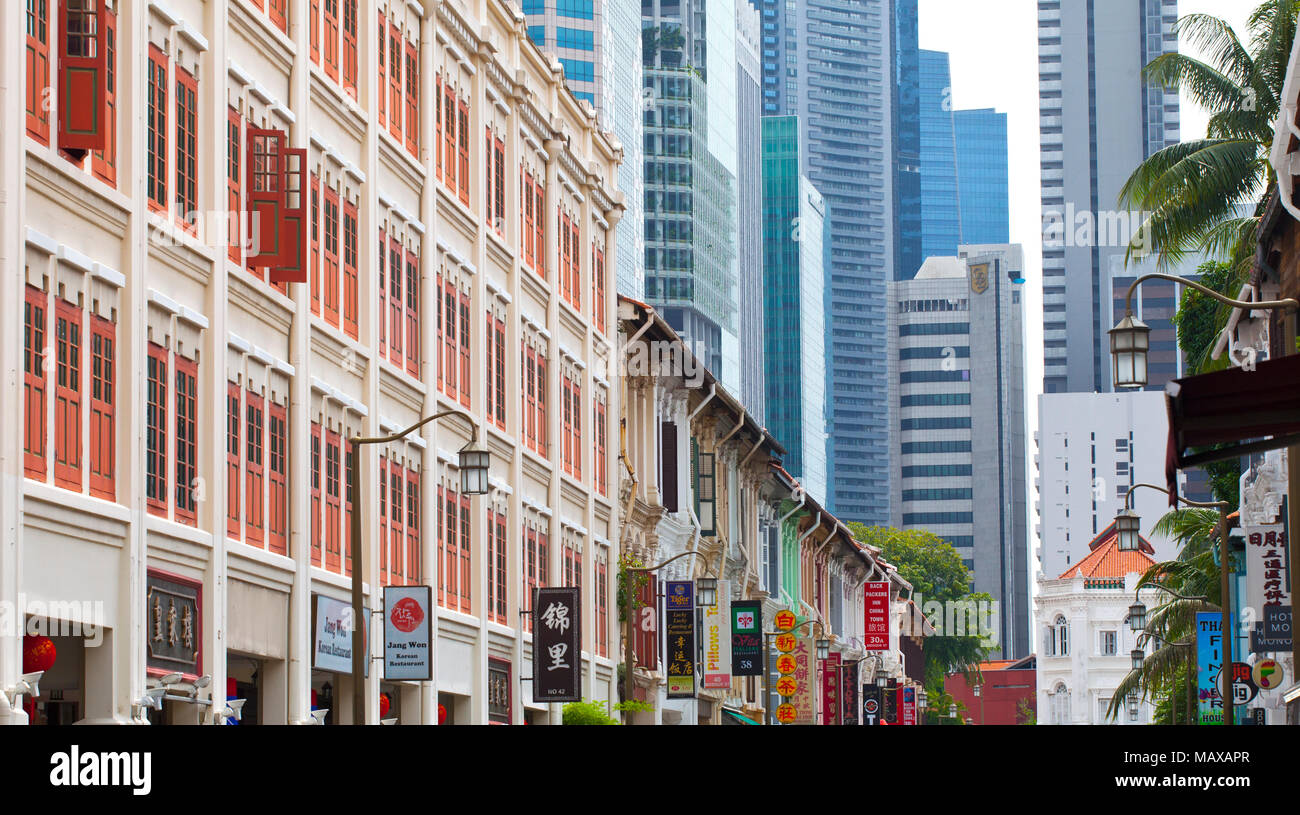Alte Häuser mit farbigen Fensterläden mit den Städten finanzielle Wolkenkratzer in der Ferne in Singapur Stockfoto