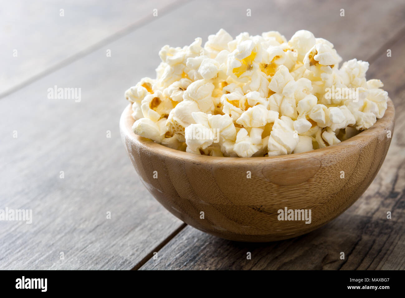 Popcorn in Schale auf Holztisch. Stockfoto