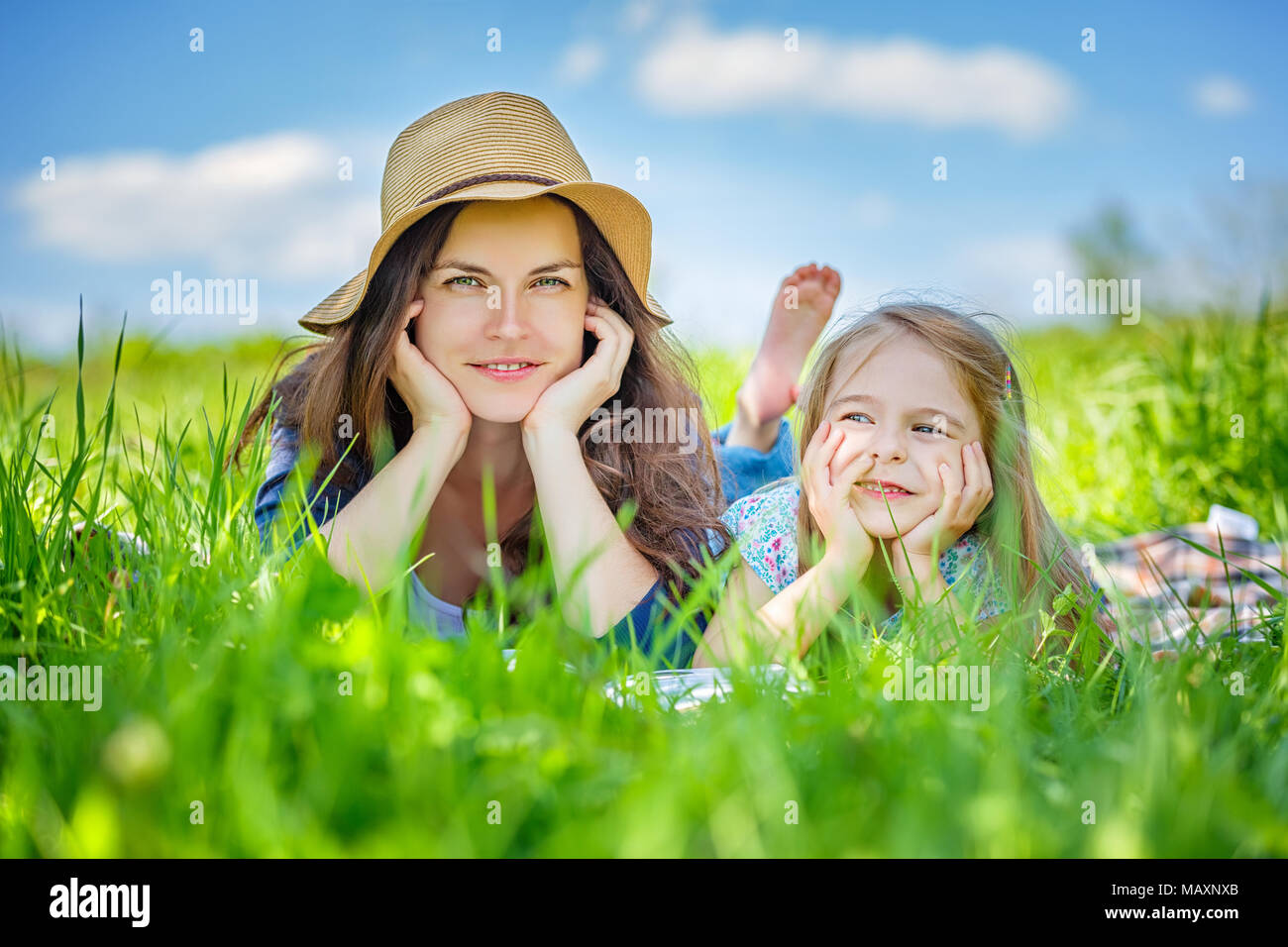 Mutter und Tochter liegen auf grünem Gras genießen Sie den Sommer Tag Stockfoto