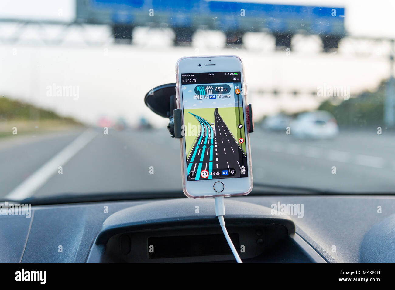 Über TomTom Navi App auf das iPhone während der Fahrt auf der Autobahn M25, Großbritannien Stockfoto