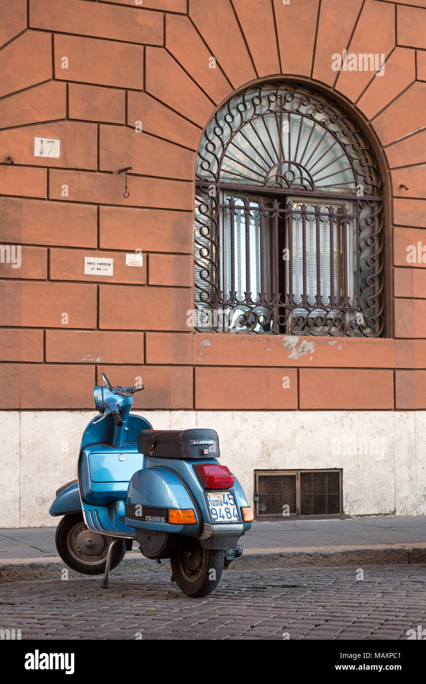 Einen alten berühmten blauen Piaggio PX 150 E Scooter auf einer gepflasterten Straße in Rom, Italien, geparkt. Stockfoto