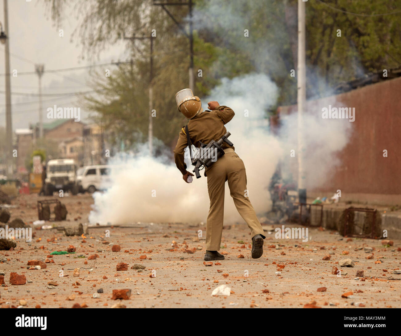 (180405) - SRINAGAR, April 5, 2018 (Xinhua) - Ein indischer Polizist wirft Steine auf Studenten (unsichtbar) von Amar Singh College in Srinagar, Stadt, die Hauptstadt des indischen Sommers-kontrollierten Kaschmir, 5. April 2018. Studenten protestieren gegen zivile und militante Morde mit den Streitkräften der Regierung am Donnerstag. (Xinhua / Javed Dar) (djj) Stockfoto