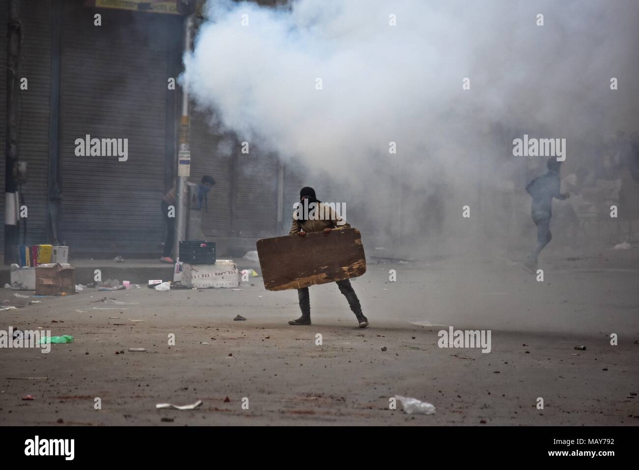 April 5, 2018 - Srinagar, J&K, Indien - ein Gas shell Zerreißen durch indische Polizist explodiert in der Nähe eines Kaschmirischen student Protester bei Zusammenstößen in Srinagar, Indien verwalteten Kaschmir gefeuert. Heftigen Auseinandersetzungen zwischen Regierungstruppen und Studenten in Srinagar am Donnerstag, da das Tal über die Tötung von 17 Menschen, darunter 13 Kämpfer und 4 Zivilisten in getrennten Begegnungen im Süden Kaschmir angespannt bleiben. Die Polizei setzte Tränengas Rauch Granaten weg die Demonstranten zu jagen. Die Gewalt erschüttert Kaschmir-tal am Tag, wenn die Behörden hob Beschränkungen nach vier Tagen des shutdown. (Cre Stockfoto