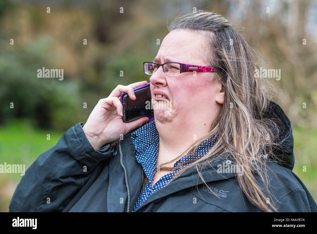 Kaukasische Frau auf dem Handy reagiert auf schlechte, schockierende oder ekelhafte Nachrichten. Schockiert. Schlechtes Nachrichtenkonzept. Angewiderter Gesichtsausdruck. Stockfoto