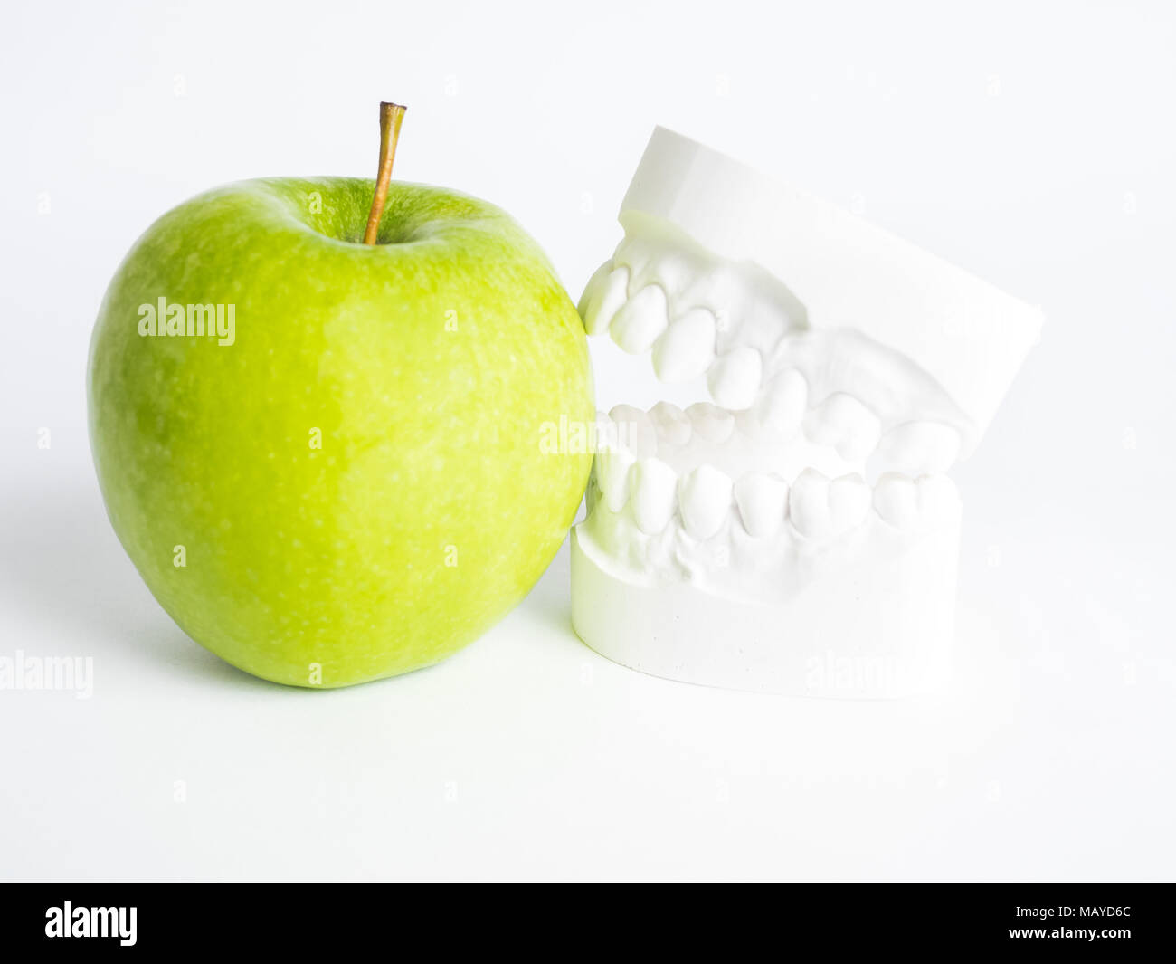 Der Putz bit beißt gegen einen grünen Apfel Stockfoto