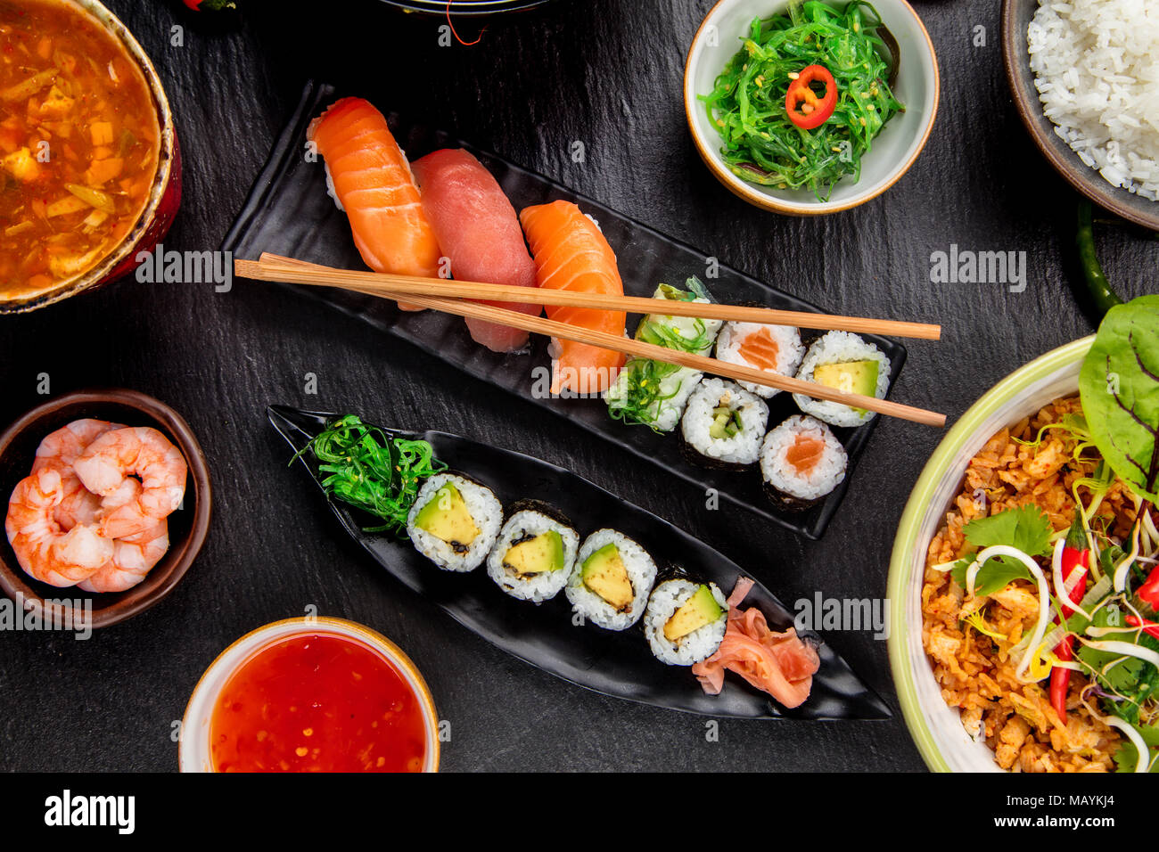 Asiatische Sushi Variation mit vielen Arten von Mahlzeiten. Kari, Suppe, Reis und Gemüse. Ansicht von oben, auf schwarzen Stein serviert. Stockfoto