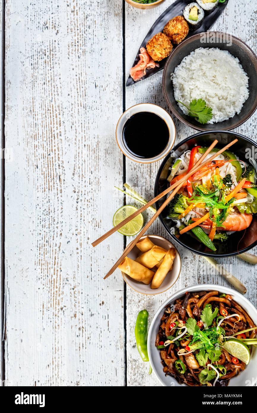 Asiatische Lebensmittel Variation mit vielen Arten von Mahlzeiten. Kari Reis, Nudeln und Gemüse. Ansicht von oben, auf alten Holzbrettern serviert. Stockfoto